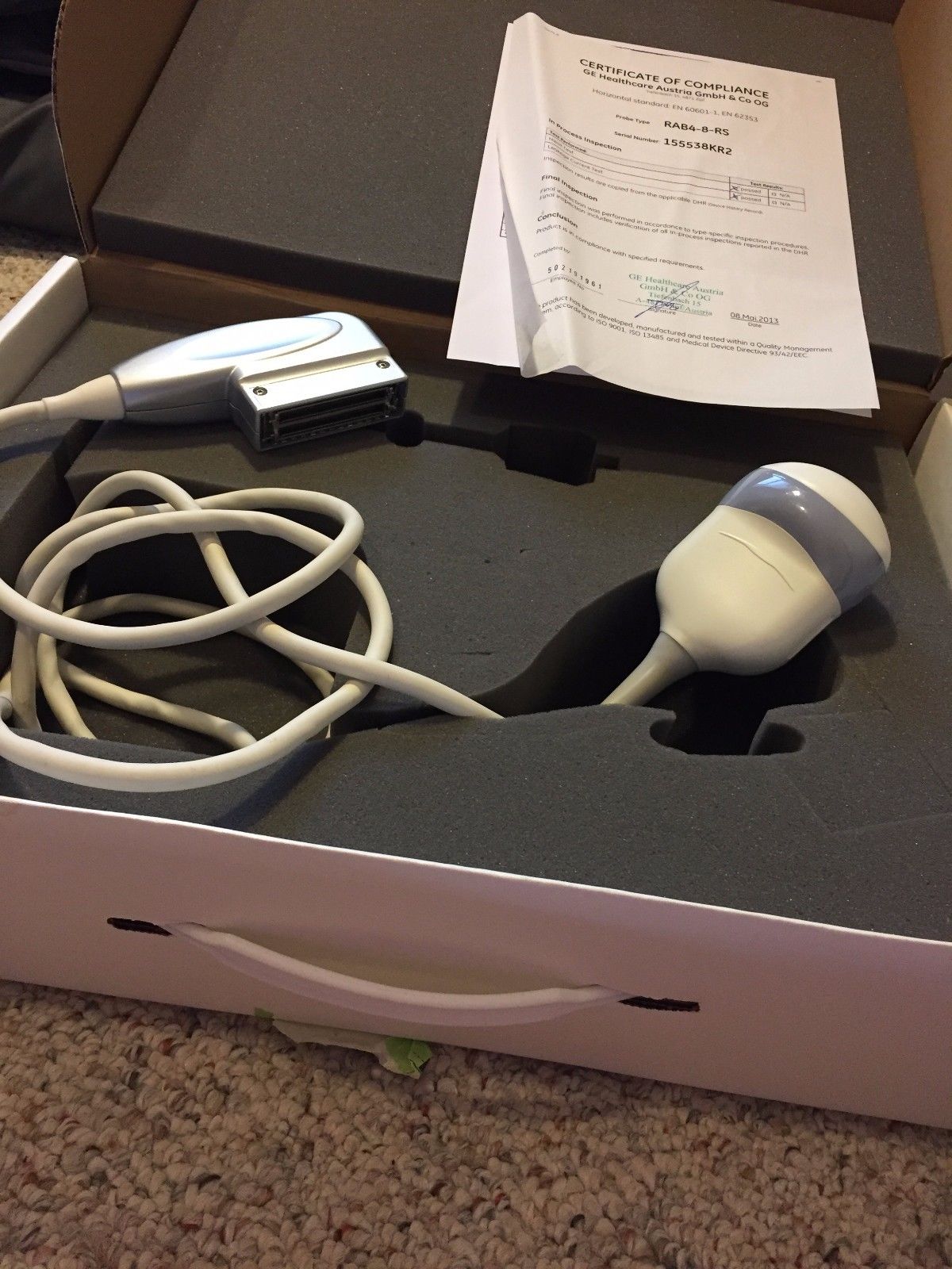 a box with a probe and a cord in it