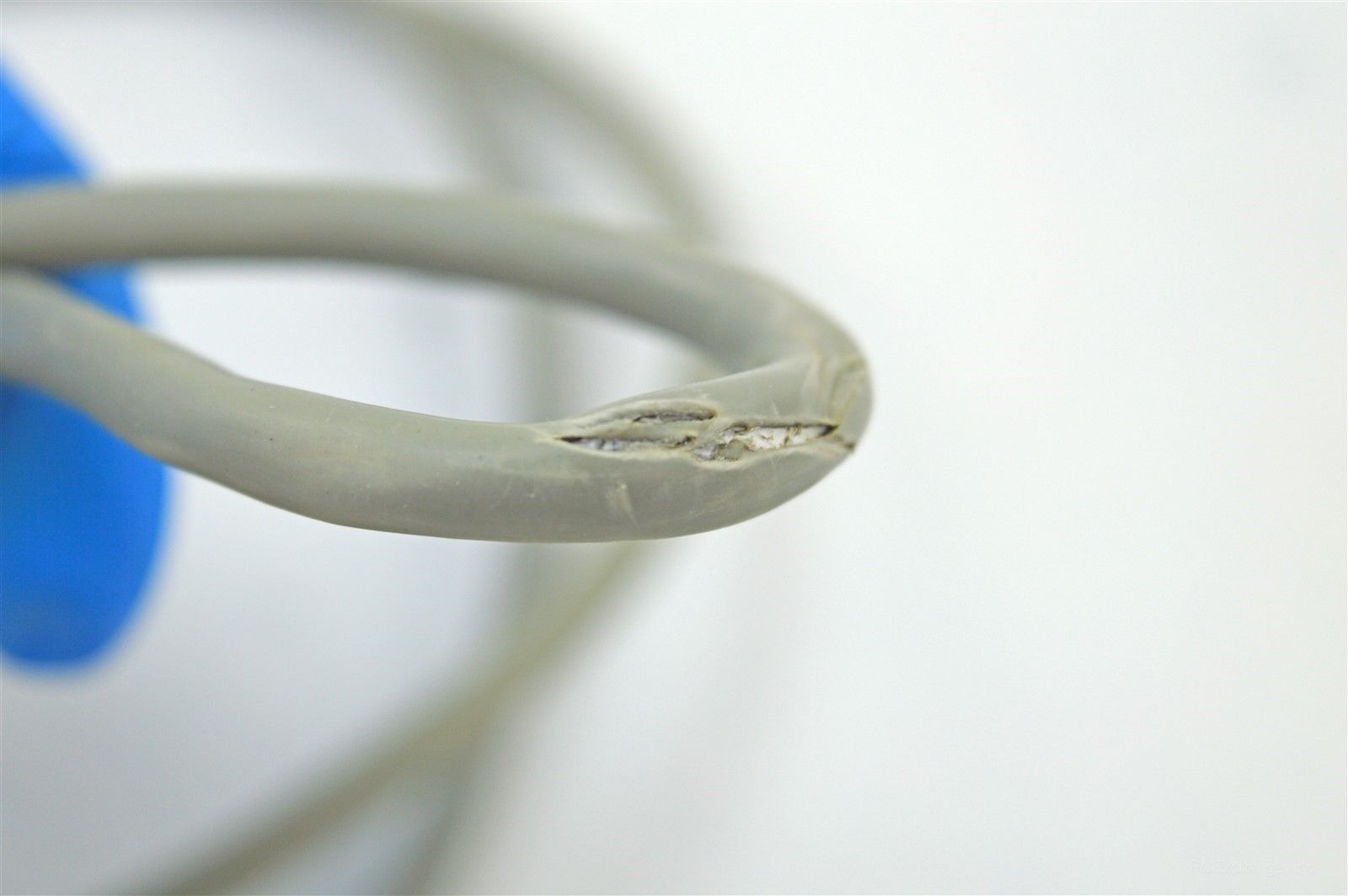a close up of a cable with a blue hands touching