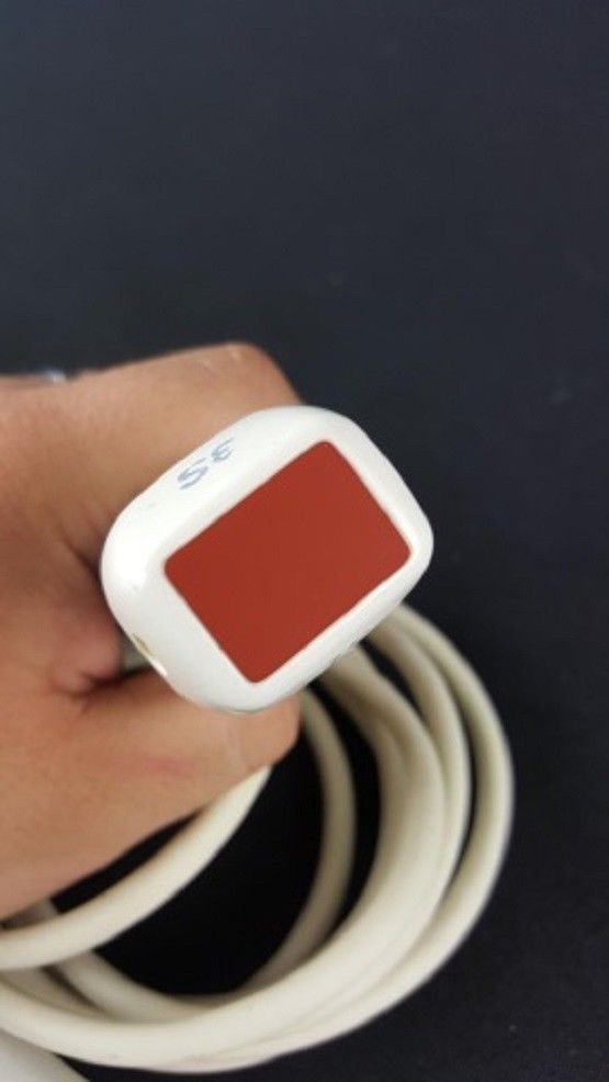 a hand holding a red and white probe