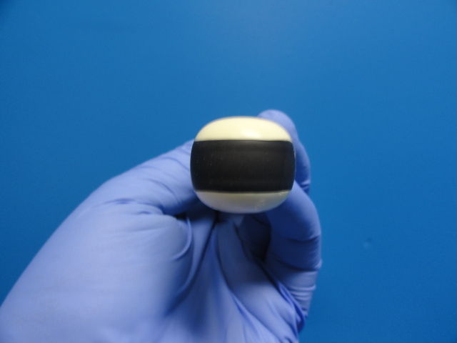 a gloved hand holding a probe head object