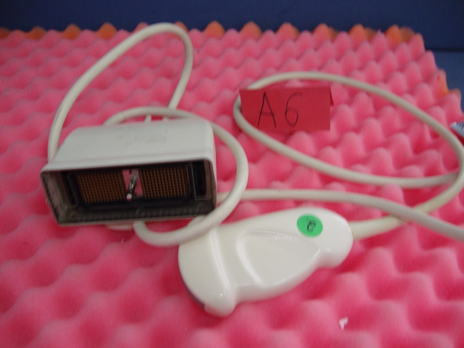 a white probe sitting on top of a pink blanket