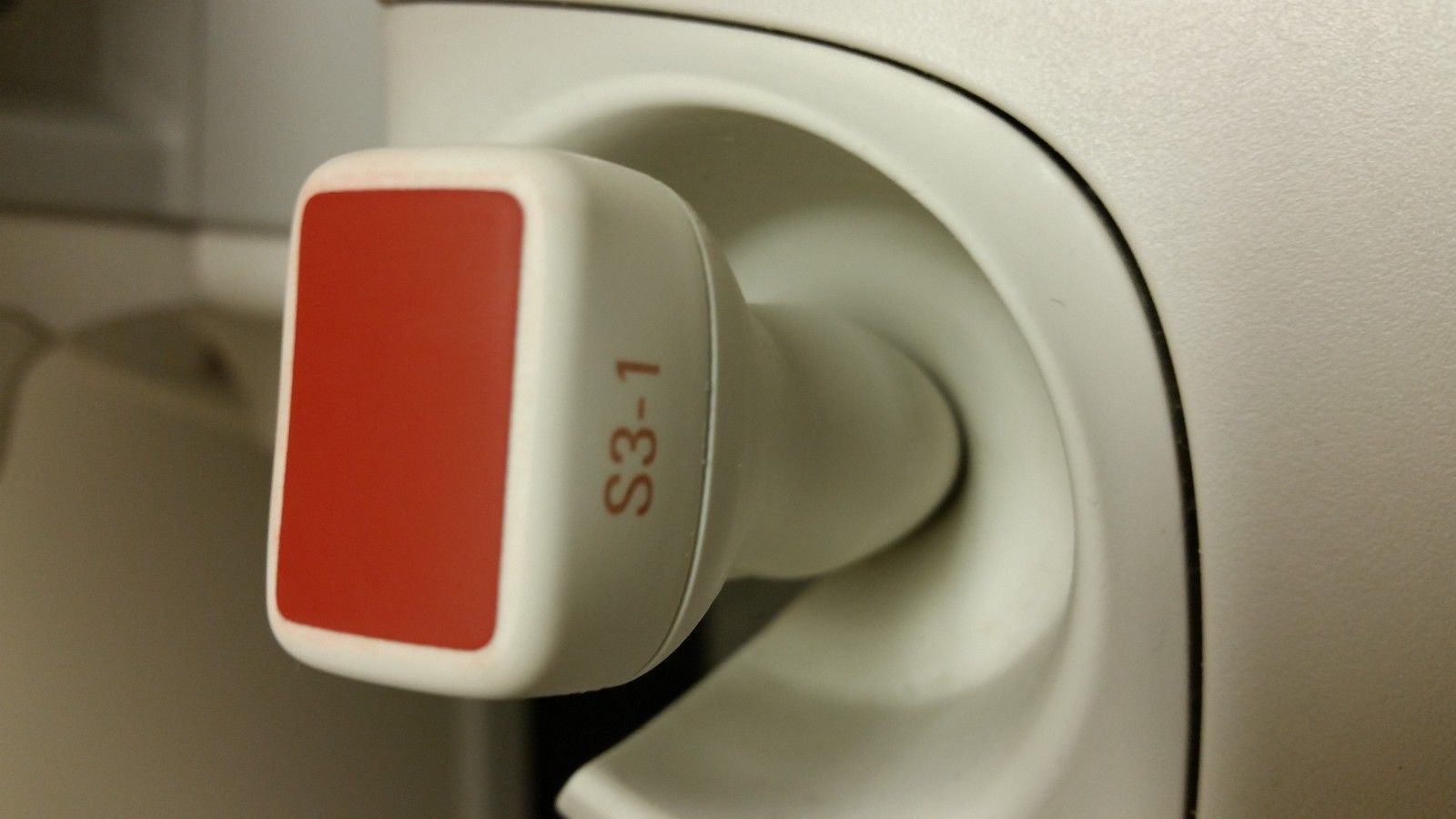 a close up of a red and white probe head
