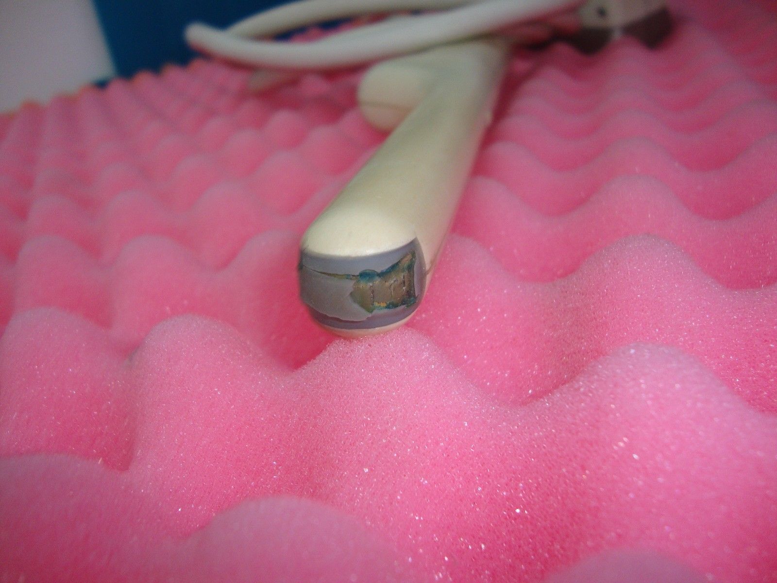 a close up of a probe head on a pink surface