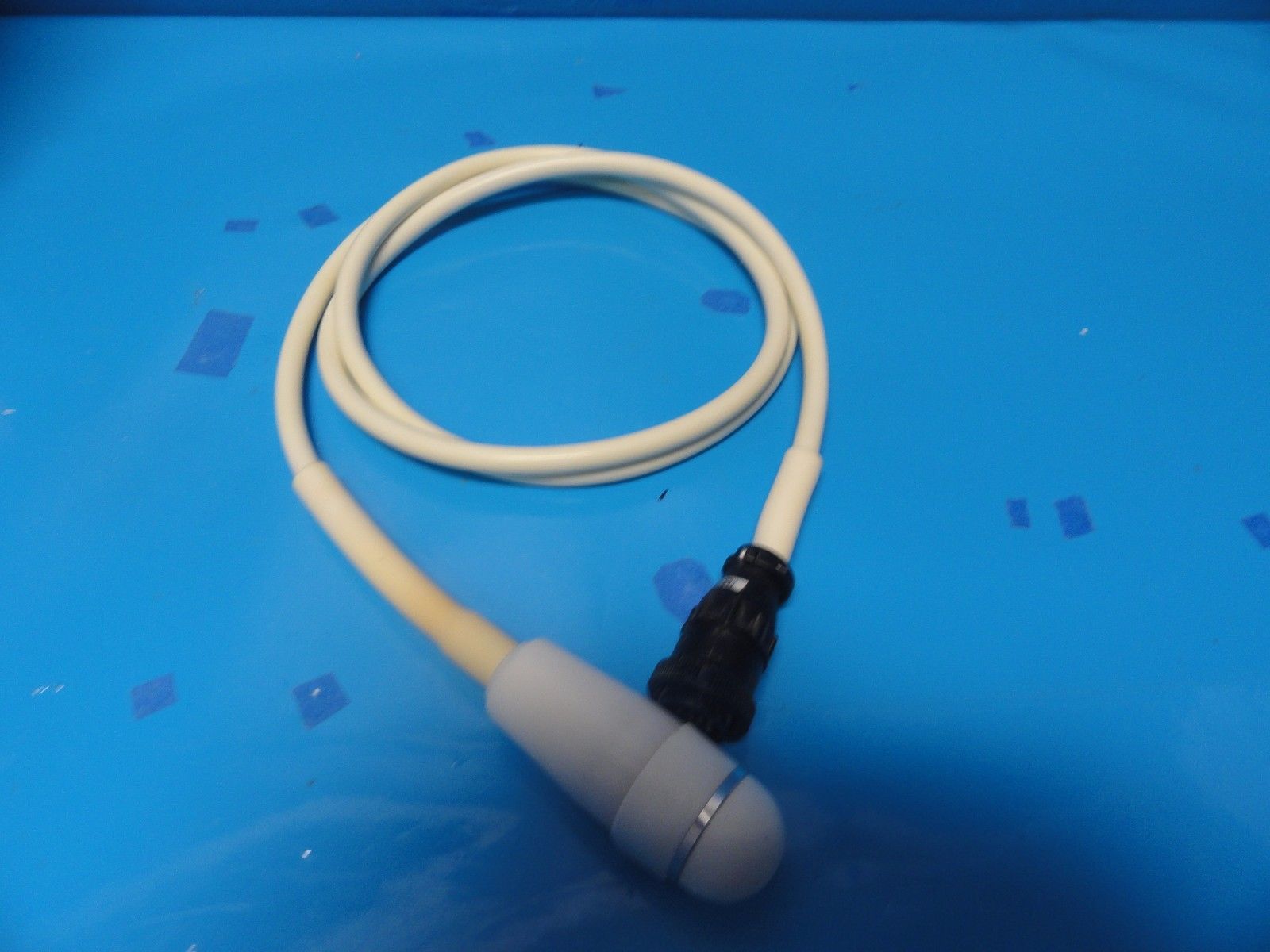 a white cord connected to a white cord on a blue surface